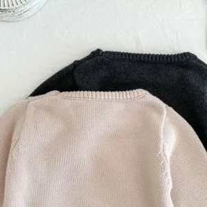 Detailansicht des weichen Babypullovers, klassisches Rundhalsausschnitt-Design, feiner Strick.