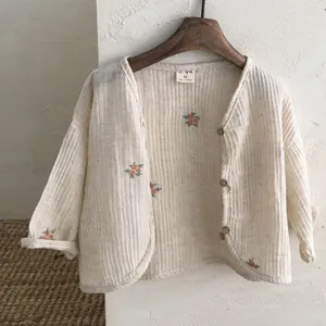 Detailed view of baby minimalist beige floral embroidered cardigan with wooden buttons.