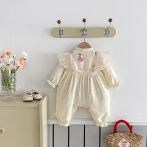 Dettaglio tutina neonato stile cinese chic, maniche lunghe con volant, tessuto morbido.