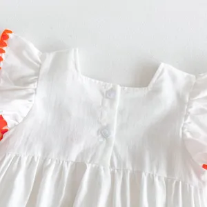 Detailed shot of a cute white baby dress with orange ruffled sleeves and back buttons.