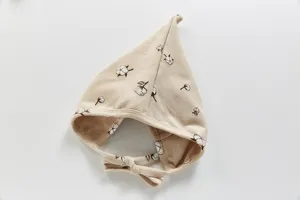 Nahaufnahme der süßen Baby-Baumwollmütze mit zartem Blumenmuster und weichen Bindebändern.