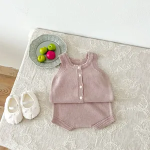 Vue détaillée de l'ensemble gilet et short tricoté rose pour bébé fille et garçon.