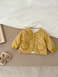Nahaufnahme der kuscheligen gelben Steppjacke für Babys mit V-Ausschnitt und Vordertaschen.