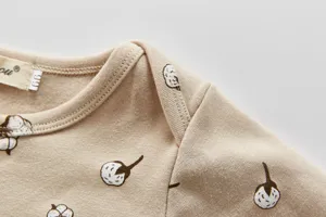 Nahaufnahme des weichen Baumwoll Baby Romper Stoffes mit feinen Nahten und Druck.