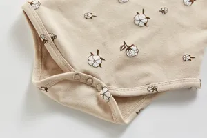 Detailansicht des Baumwoll-Babyrompers mit niedlichem Blumenprint und praktischen Druckknöpfen.