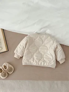 Detailansicht der gesteppten Kleinkind-Jacke, warme Winter-Babykleidung im Beigeton.