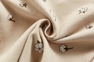 Nahaufnahme des Stoffes mit weicher Baumwolltextur und süßem kleinen Baumwollkapsel-Print.
