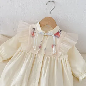 Primo piano dettaglio della tutina neonata stile cinese tradizionale con volant e perle.