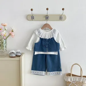 Detail view of toddler girl's chic denim 3-piece set with lace collar and cute bows.