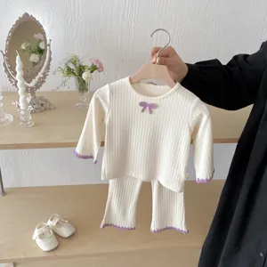 Cute baby girl ribbed long sleeve top and flared pants set with purple bow detailing.