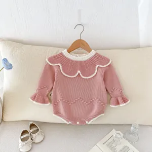 Rosa Baby Strampler aus Strick mit welligem Kragen und süßen Bommel Details für Kinder.