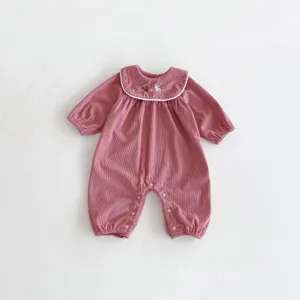 Combinaison bébé fille en velours côtelé rose avec col blanc et broderie, manches longues.