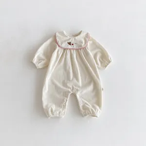 Vue détaillée de la combinaison bébé en velours côtelé avec broderie lapin et col rose.