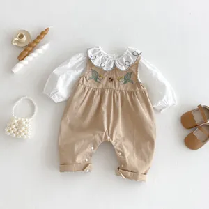 Infant baby girl clothing set detail showing cute embroidered collar blouse and tan romper.