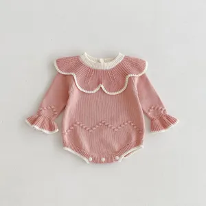 Nahaufnahme des rosa Baby Strickstramplers mit weißem kontrastierenden Rüschenkragen.