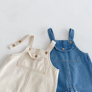Close-up detail of infant denim bib overalls, featuring snap buttons and front pocket design.