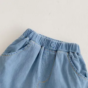 Close up detail of baby denim shorts elastic waistband, soft fabric texture with button.