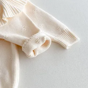 Baby knit sweater detail view, cute ruffle collar, soft cream white winter baby clothing.
