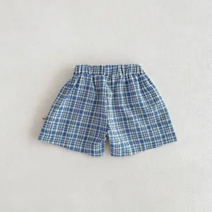 Vue détaillée de short de bébé à carreaux bleus et blancs avec taille élastique et tissu doux.