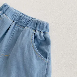 Close-up detail shot of baby light blue denim shorts, elastic waistband, soft fabric.