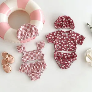 Détail de l'ensemble de maillot de bain pour bébé fille, motifs floraux et à carreaux.