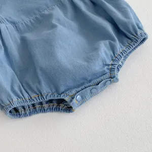Infant baby soft denim romper detail, light blue summer infant clothing close up view