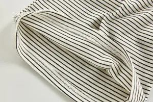 Black and white striped baby t-shirt cuff detail, fine stitching, soft fabric close-up