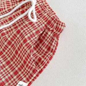 Short décontracté à carreaux rouge et blanc bébé gros plan tissu texturé cordon.