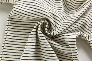 Close-up detail of black and white striped baby clothing fabric showing soft knit texture.