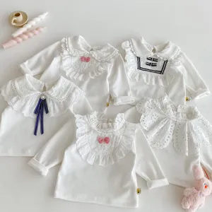 Detailansicht von weissen Langarm-Babyshirts fuer Maedchen mit filigranen Spitzen-Rueschenkragen.