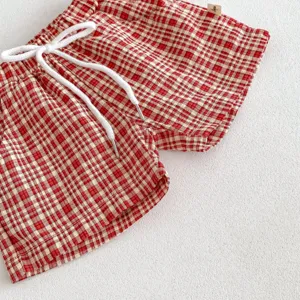 Détail short bébé carreaux rouge et blanc, tissu doux avec cordon de serrage réglable.