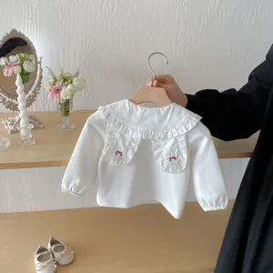 Blouse en coton à manches longues pour bébé avec col volanté et broderie mignonne.