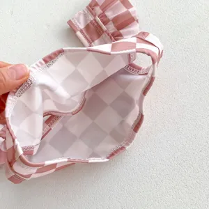 Détail de bas de bikini bébé à carreaux rose et blanc, maillot de bain pour tout-petit.