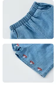 Denim shorts detail shot, elastic waistband, cute mushroom embroidery, soft fabric.