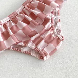 Joli détail de maillot de bain bébé fille à carreaux roses, volants charmants, maillot confortable.