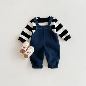 Ensemble de vêtements d'automne pour bébé avec sweat rayé noir et blanc et salopette en jean.