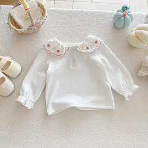 Détail t-shirt blanc manches longues bébé avec joli col volant brodé de fraises ravissant.