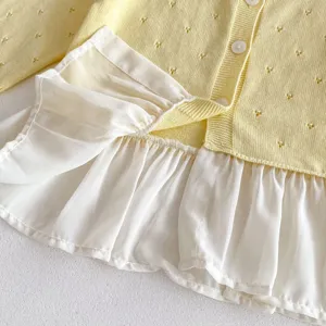 Knit cardigan detail, yellow hollow knit pattern with white chiffon ruffled hem, soft fabric.