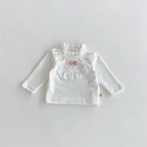 Baby Mädchen weißes Langarmshirt mit Spitzenrüschenkragen und pinker Schleife Detailansicht.