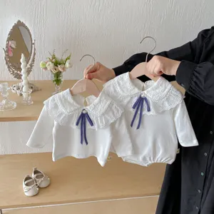 Süßes weißes Langarmshirt für Babys mit Spitzenkragen und blauer Schleife im Herbst.