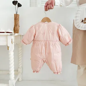 Detailed close-up view of the cute pink baby quilted cotton romper with bow patterns.