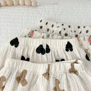 Detailopname van baby katoenen mousseline pofbroekjes met beren en hartjes print.