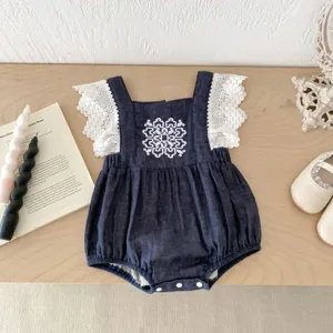 Lindo mameluco de mezclilla para bebé niña con mangas de encaje blanco y bordado geométrico.