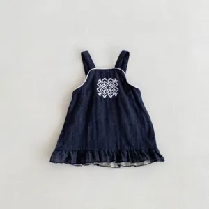 Detalle vestido mezclilla niña pequeña, bordado blanco pecho, bonito dobladillo con volantes.