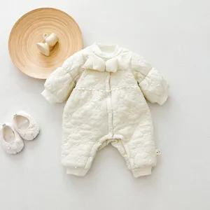 Detailed close-up view of infant quilted winter jumpsuit featuring cute bow and soft fleece lining.