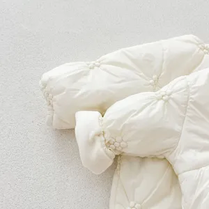 Infant winter padded romper detail, creamy white baby thermal outerwear, cute quilted design.