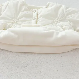 Infant baby white quilted cotton romper detail shot, soft winter outerwear clothing closeup.