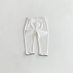 White ribbed baby leggings featuring cute black lettuce trim details closeup view