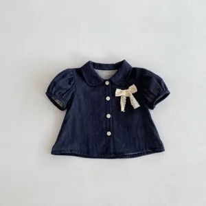 Vista detallada de blusa de bebe azul oscuro de manga corta con lazo de encaje lindo.