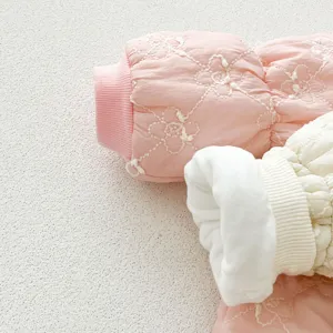 Detailed view of infant winter quilted romper sleeve with floral embroidery and ribbed cuffs.